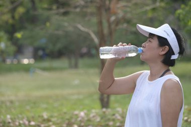 Asyalı kadınlar yaz tatilinde parkta egzersiz yaparlar..