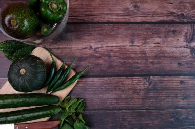 Yeşil sebzeler vücuda iyi gelir. Yeşil sebzeler masanın üzerine konur, yukarıdan izlerler..