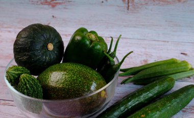 Yeşil sebzeler vücuda iyi gelir. Yeşil sebzeler masanın üzerine konur, yukarıdan izlerler..