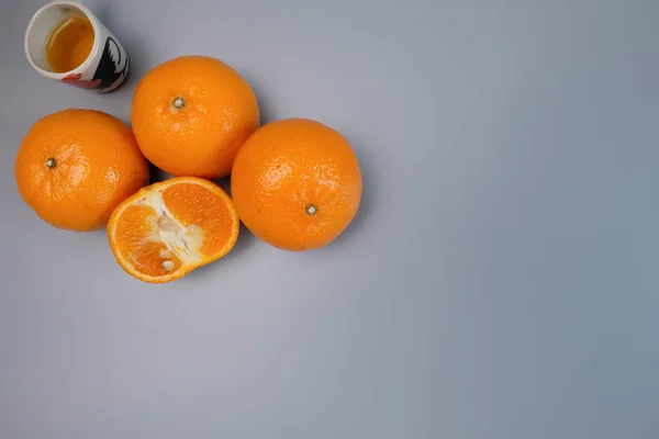 Fresh yellow oranges from the fields on a gray background