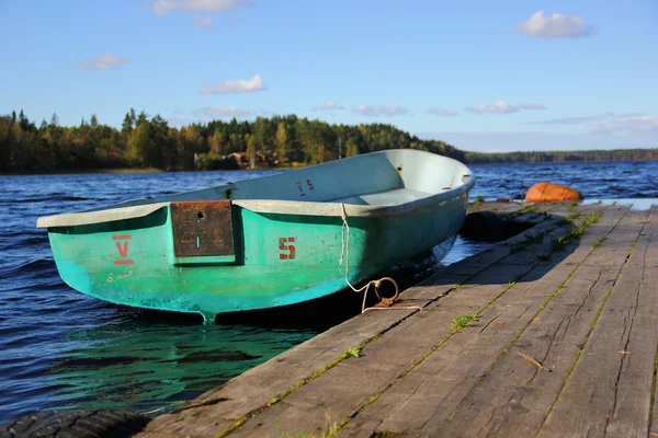 Um cais de madeira e amarrou o barco — Fotografia de Stock