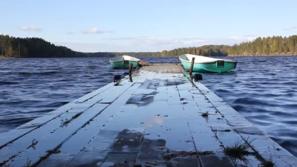 Muelle de madera y barcos balanceándose sobre las olas — Vídeo de stock