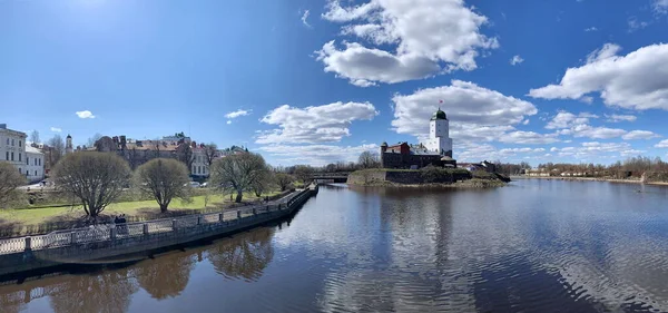 Rusya, Vyborg, 2 Mayıs 2021 Vyborg Şatosu 'nun adadaki panoramik manzarası, St. Olaf Kulesi, çevresi su, dolgu, eski şehir evleri, güneşli gün, hafif su dalgaları, iç turizm, güneşli gün, mavi gökyüzü.