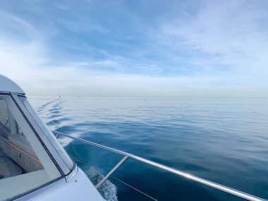 Beyaz yatın önünden, mavi denizin pruva çekimi, oldukça pürüzsüz su, gökyüzüne dönüşüyor, şaşırtıcı Aralık