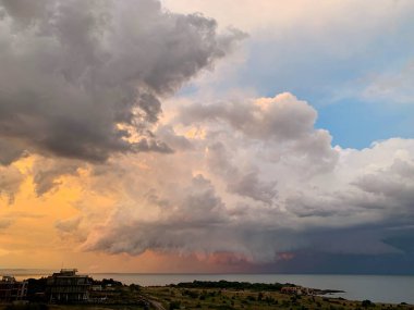 Denizin üzerinde fırtına bulutlarıyla güzel bir gökyüzü, griden pembe-turuncuya, mavi bir parça, güzel doğal bir resim