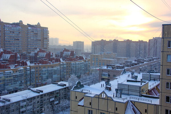 The roofs of modern high-rise buildings, top view, sunrise frosty morning, it's snowing