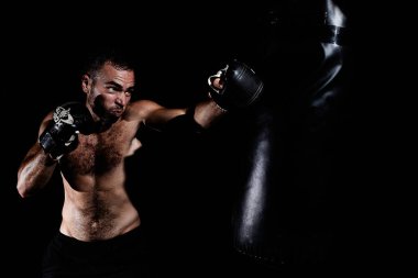 Kaslı genç adam antrenman yapıyor ve vuruyor.