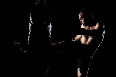 Kaslı genç adam antrenman yapıyor ve vuruyor.