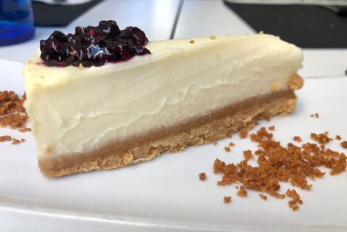 Lezzetli ve kremalı peynirli kek, üstünde böğürtlen reçeli.