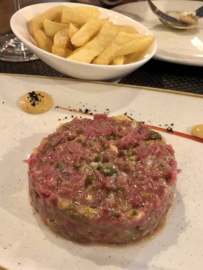 Patates kızartmasıyla servis edilen lezzetli biftek tartartarı.