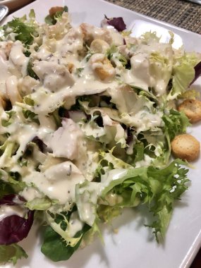 Tavuklu Sezar salatası, çiftlik sosu ve kızarmış ekmek.