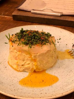 Karides carpaccio soğuk patates salatasının üstünde servis edilir.