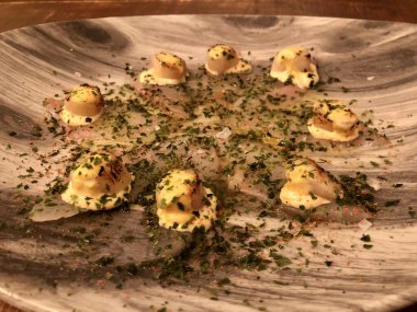 Tiradito 'lar, ince dilimlenmiş beyaz balıklar ve üstünde deniz tarakları.