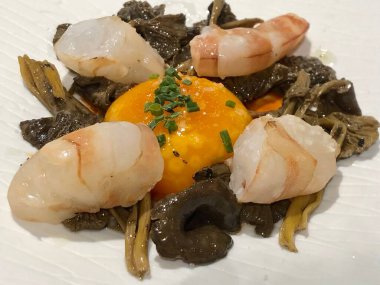 Michelin restoranında yumurta sarısı ve mantarla servis edilen karides.