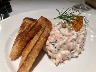 Kızarmış ekmekle servis edilen mayonezli karides salatası.