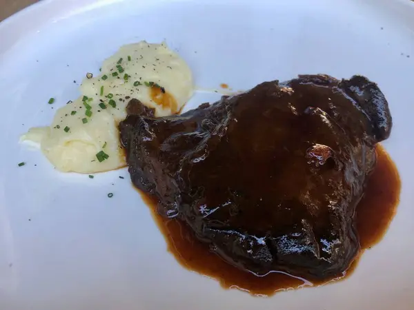 Délicieux steak servi avec sauce et purée de pommes de terre — Photo