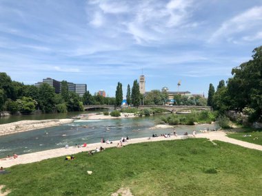 Münih, Almanya - 26 Mayıs 2018: İnsanlar Isar nehrinin kenarında güneşleniyor