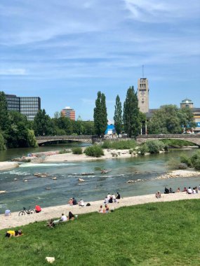 Münih, Almanya - 26 Mayıs 2018: İnsanlar Isar nehrinin kenarında güneşleniyor