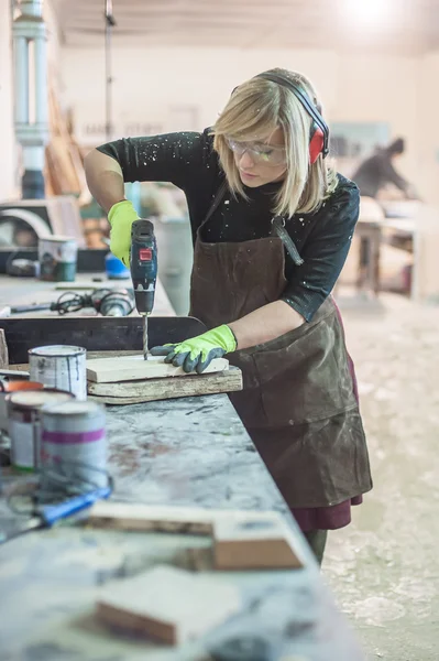 Falegname femminile usando il trapano elettrico — Foto Stock