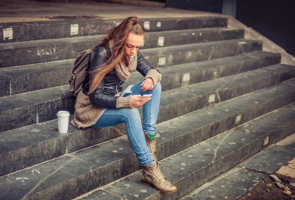 Junge Frau benutzt Handy auf der Straße — Stockfoto