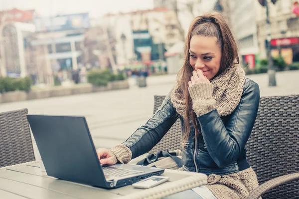 Estudiante joven usando portátil en la cafetería al aire libre — Foto de Stock