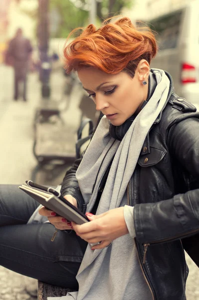 Junge Frau auf einer Straßenbank mit Tablet-Computer — Stockfoto