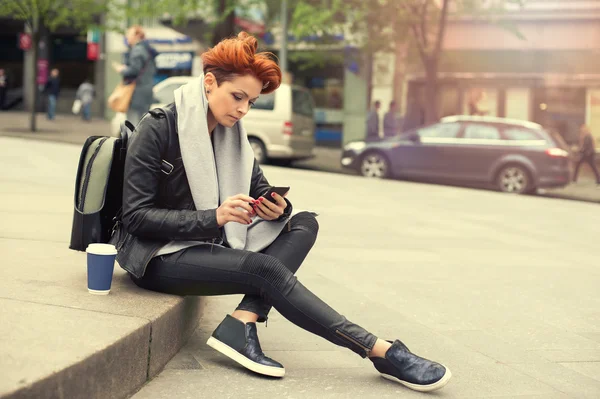 Junge Frau benutzt Handy auf der Straße — Stockfoto