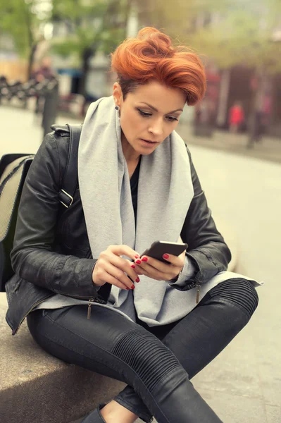 Junge Frau benutzt Handy auf der Straße — Stockfoto