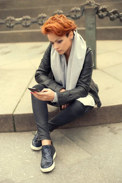 Junge Frau benutzt Handy auf der Straße — Stockfoto