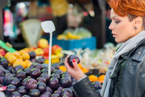 Kadın sokak pazarında meyve satın alır. — Stok fotoğraf