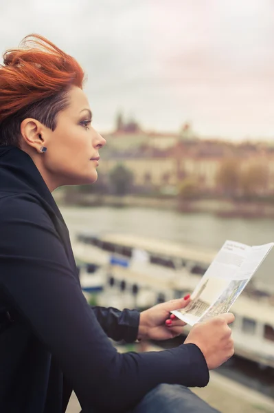Женщина-турист смотрит на путеводитель по городу — стоковое фото