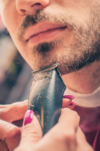 Barber barbering en klient med trimmer - Stock-foto