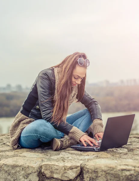 Hermosa joven estudiante El uso de ordenador portátil en el parque — Foto de Stock