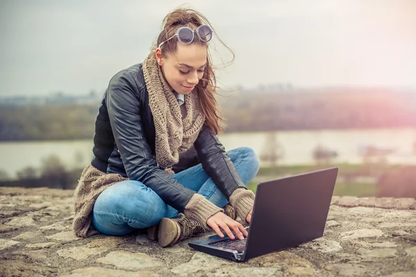 Hermosa joven estudiante El uso de ordenador portátil en el parque — Foto de Stock