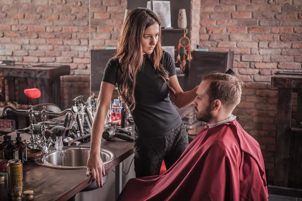 Kvinnlig frisör frisyr hår av mannen i stolen — Stockfoto