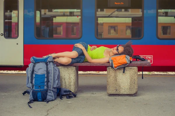 Ženské batohem turistické podřimuje na lavičce — Stock fotografie