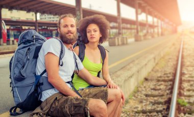 Mutlu genç ve güzel çift demiryolu oturan turist