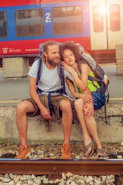 Happy young and beautiful couple of tourists sitting at the rail — Stock Photo, Image