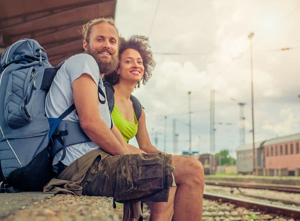 Mutlu genç ve güzel çift demiryolu oturan turist — Stok fotoğraf