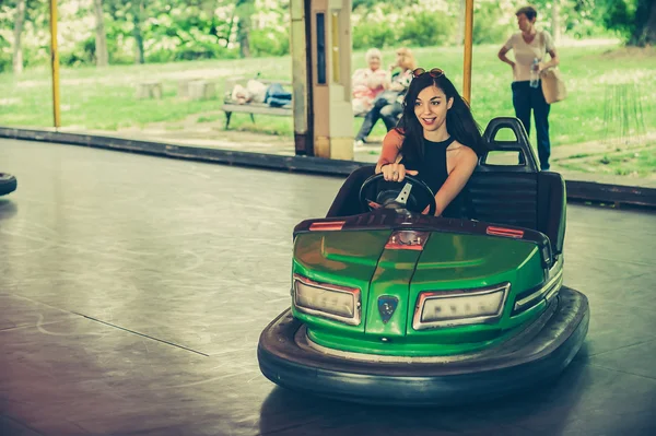 Jonge vrouw met plezier in elektrische Botsauto — Stockfoto