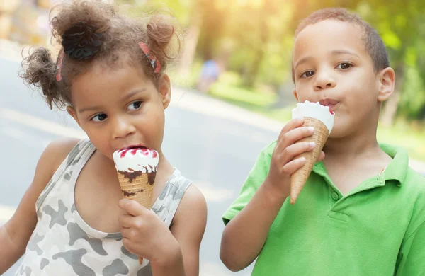 Adorable hermano y hermana comiendo helado cono — Foto de Stock