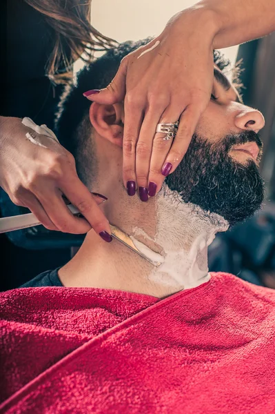 Kvinde barber barbering en klient - Stock-foto