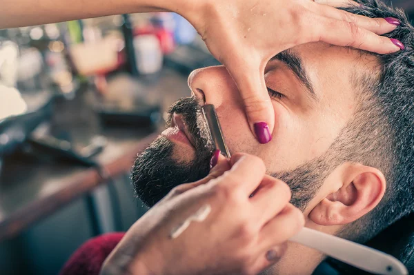 Kvinde barber barbering en klient - Stock-foto