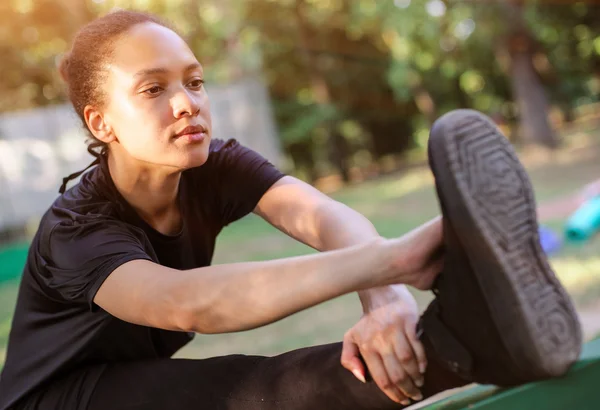 Entraînement extérieur. Fit jeune femme étirant ses jambes . — Photo