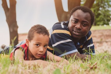 Baba ve oğul çimenlerde yatıyor.