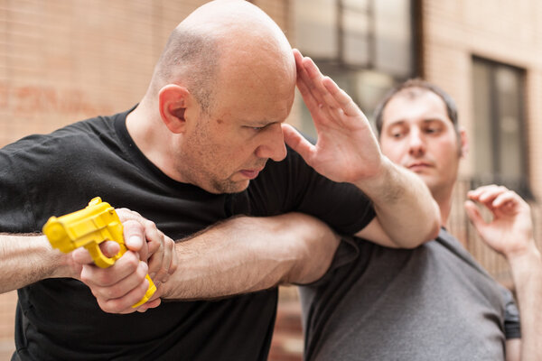 Gun Disarm. Self defense techniques against a gun point.