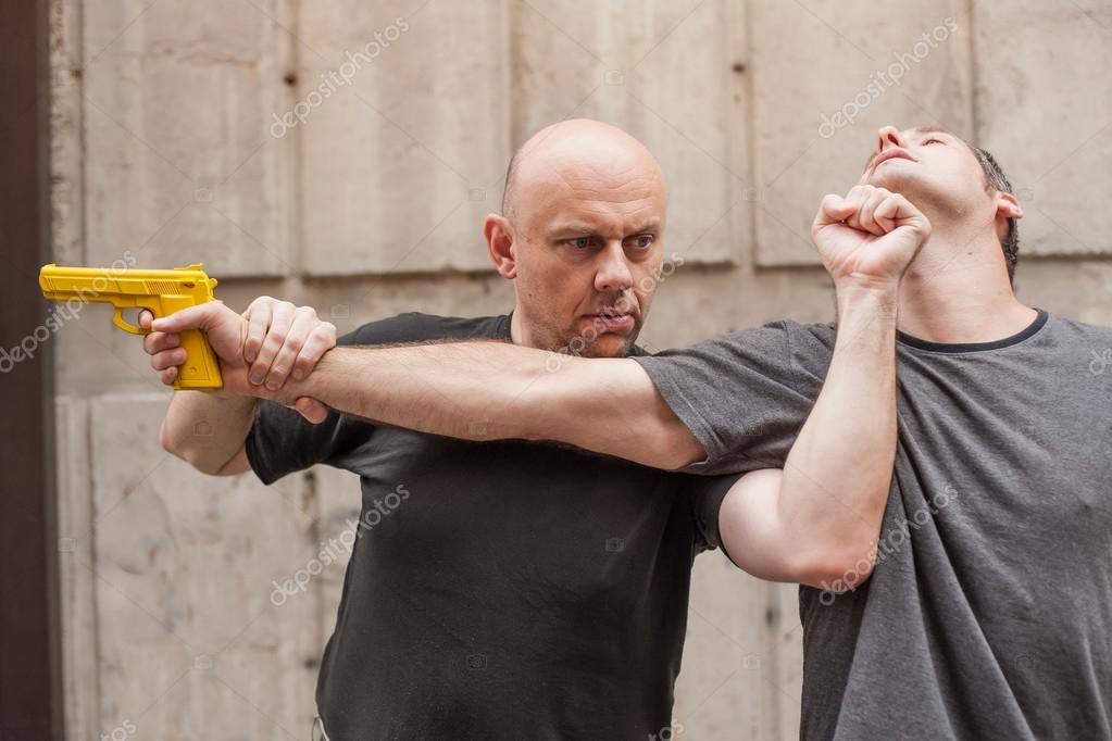 Disarm A Gun 2 Gun Disarm. Self defense techniques against a gun point. Stock Photo by