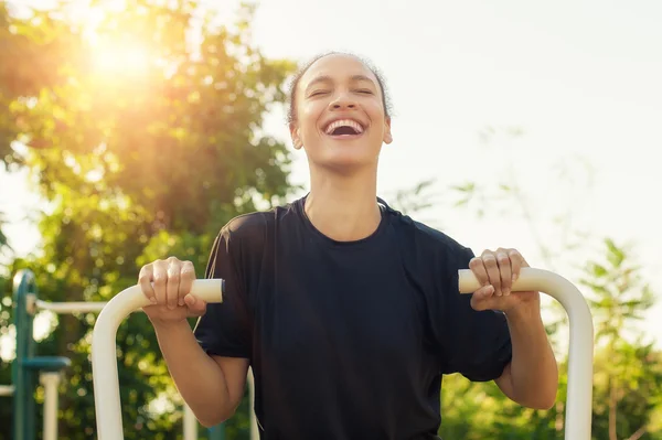 Woman exercising on elliptical trainer machine