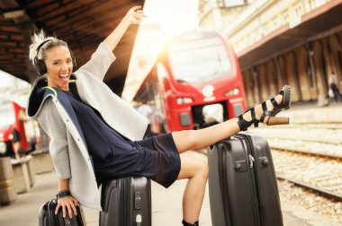 Mutlu kadın bavul üzerinde yatıyor ve demiryolu st müzik dinle