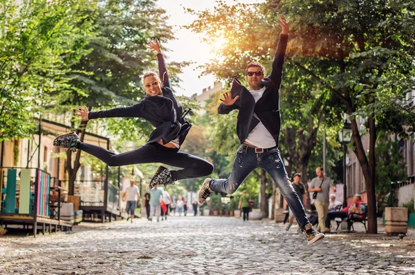 Atraktivní žena a pohledný muž, skákání na ulici — Stock fotografie